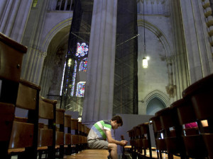 millenial-young-man-sits-alone-in-pews-of-cathedral-of-saint-john-the-divine